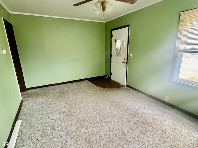 unfurnished room with ornamental molding, carpet flooring, baseboards, and a ceiling fan