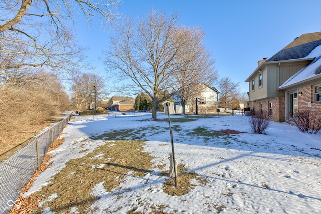 yard covered in snow with fence