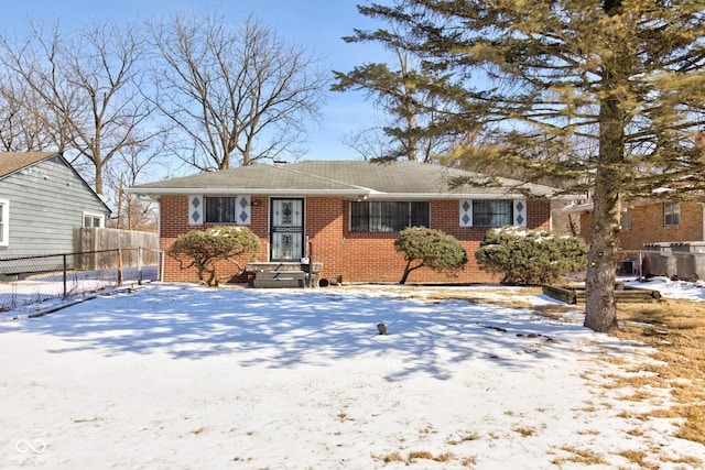 view of front of home with entry steps, fence, and brick siding