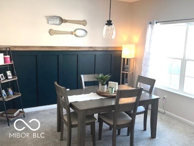 carpeted dining room with plenty of natural light and baseboards