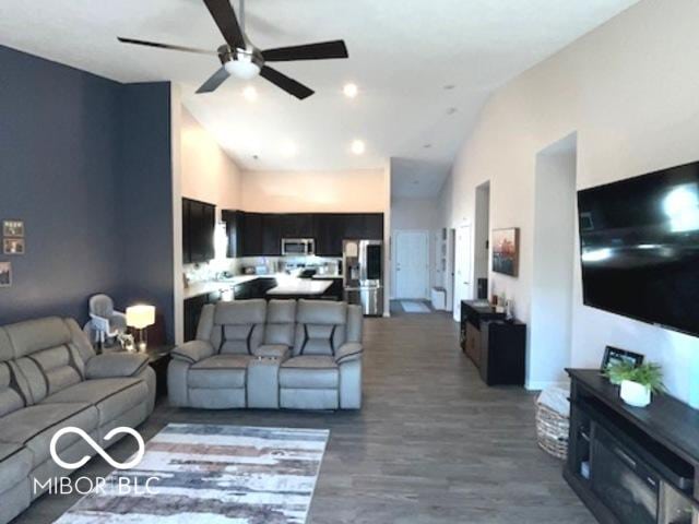 living room with high vaulted ceiling, dark wood-type flooring, and a ceiling fan