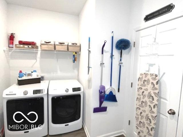 clothes washing area with laundry area, baseboards, and washing machine and clothes dryer