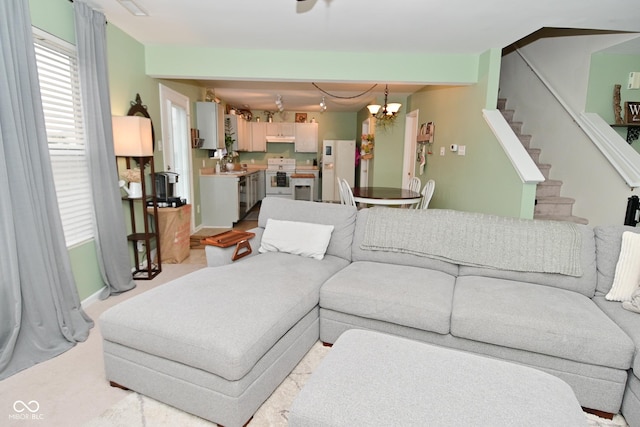 living area with stairway and an inviting chandelier