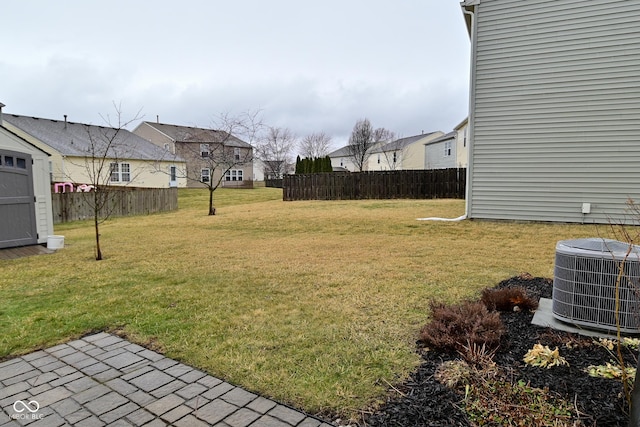 view of yard with a residential view, central AC, and fence