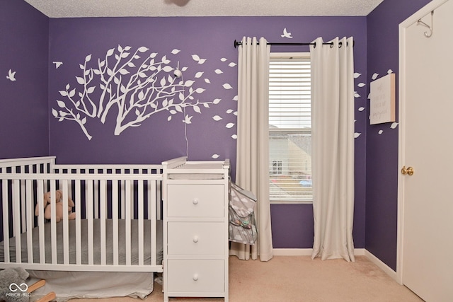 bedroom with a textured ceiling, carpet flooring, and baseboards