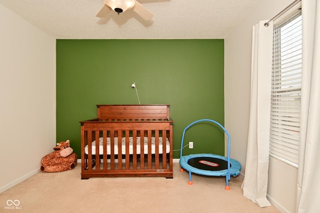 carpeted bedroom with a ceiling fan, a textured ceiling, and baseboards