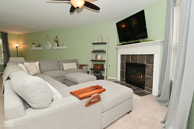 carpeted living area with a ceiling fan and a tile fireplace