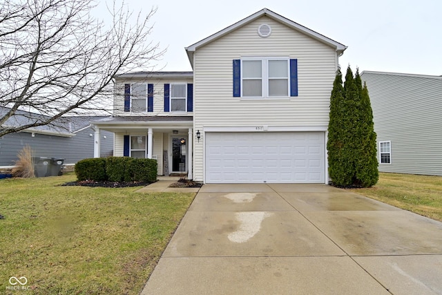 traditional-style house with driveway, an attached garage, and a front yard