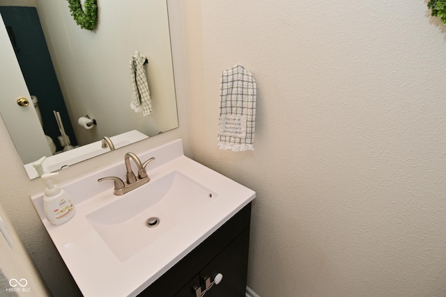 bathroom featuring a textured wall and vanity