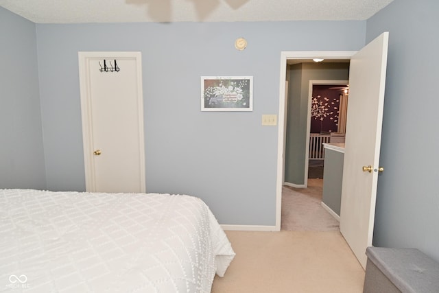 bedroom featuring baseboards and light colored carpet