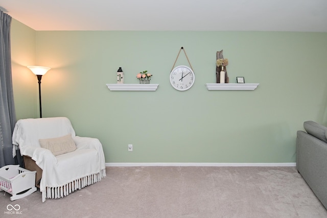 sitting room featuring carpet and baseboards