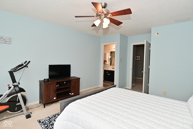 bedroom featuring a ceiling fan, light carpet, connected bathroom, a textured ceiling, and baseboards