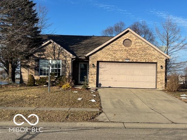 single story home with driveway, brick siding, and an attached garage