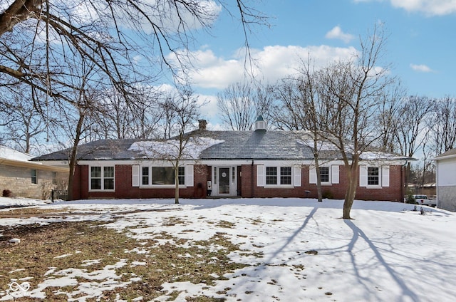 view of front of property featuring brick siding and a chimney