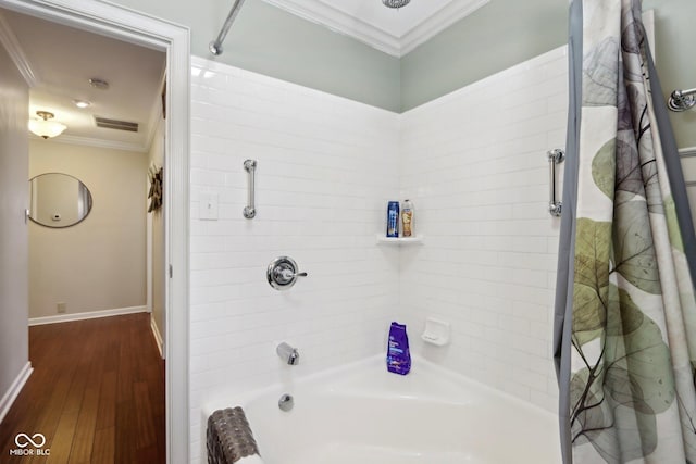 bathroom with crown molding, shower / bath combination with curtain, visible vents, wood finished floors, and baseboards