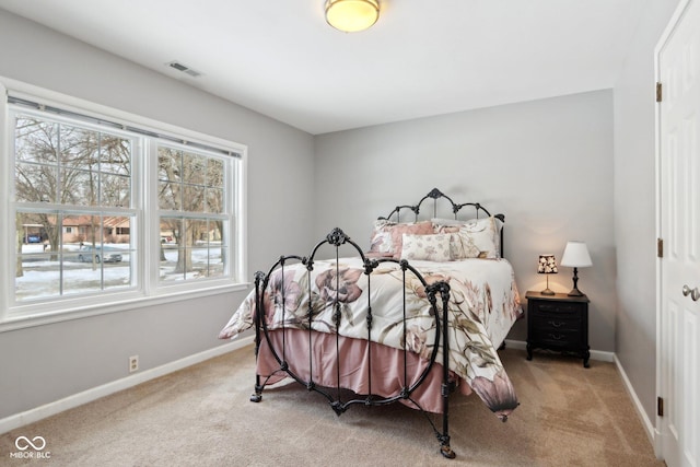 bedroom with light carpet, visible vents, and baseboards