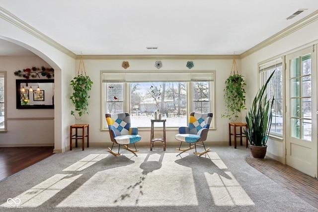 living area featuring visible vents, crown molding, and wood finished floors