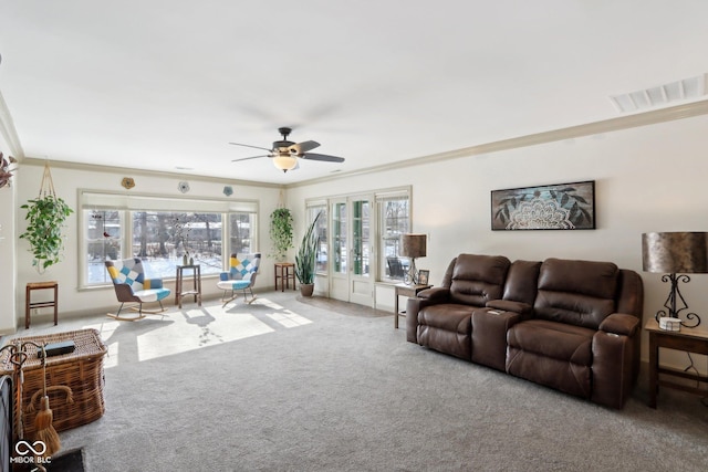 living room with carpet floors, visible vents, ornamental molding, and ceiling fan