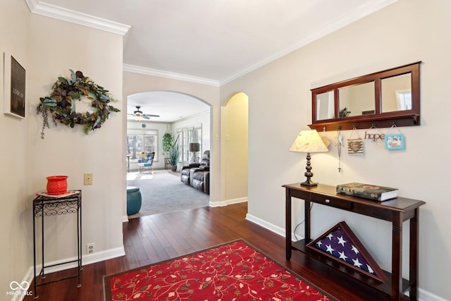 hallway featuring baseboards, arched walkways, dark wood-type flooring, and ornamental molding