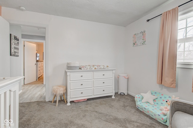 bedroom with light carpet and a textured ceiling