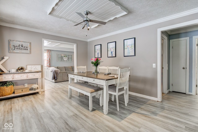 dining room with light wood-type flooring, crown molding, and a textured ceiling