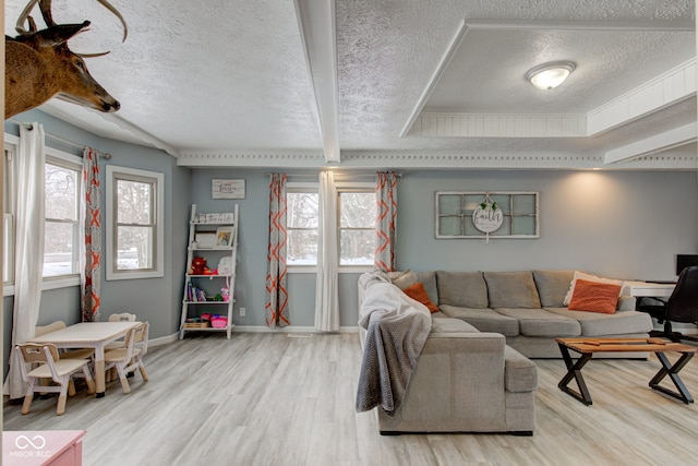 living area featuring light wood-style floors, plenty of natural light, and baseboards