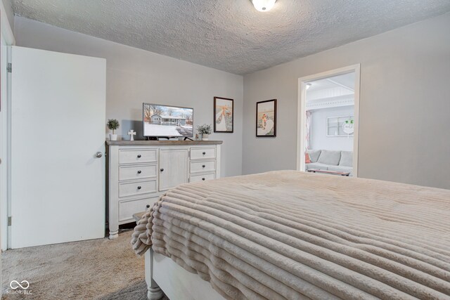 bedroom featuring a textured ceiling and light colored carpet