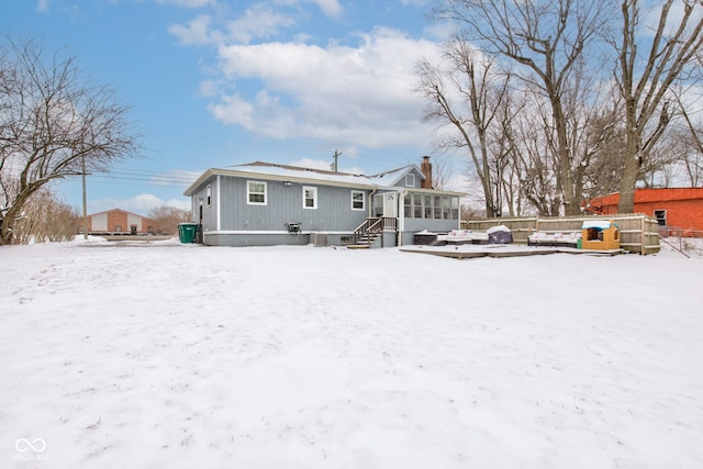 snow covered back of property featuring fence and a chimney