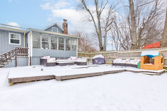 snow covered deck with area for grilling, fence, and a sunroom