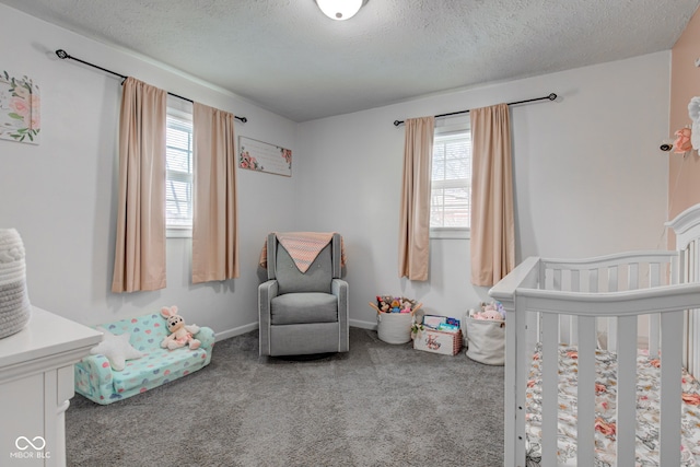 carpeted bedroom featuring a nursery area, baseboards, and a textured ceiling