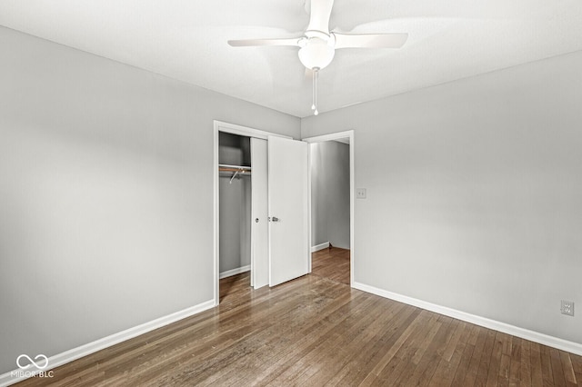 unfurnished bedroom with ceiling fan, hardwood / wood-style floors, a closet, and baseboards