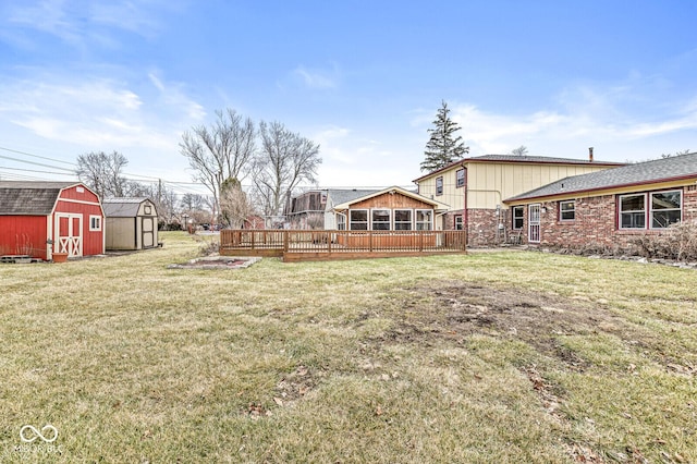 view of yard featuring a storage shed, a deck, and an outbuilding