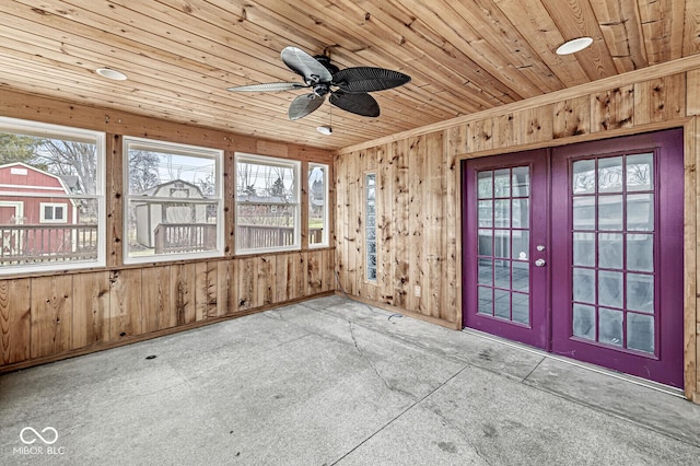 unfurnished sunroom with a ceiling fan, wood ceiling, and french doors