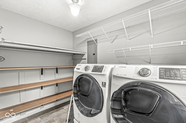 laundry area featuring laundry area, washing machine and dryer, and a textured ceiling