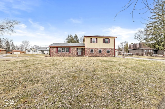 tri-level home featuring a front lawn and brick siding