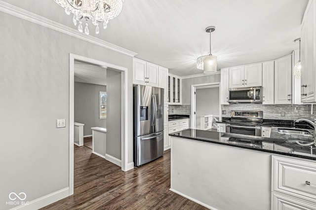 kitchen featuring dark wood-style flooring, tasteful backsplash, appliances with stainless steel finishes, white cabinets, and a sink