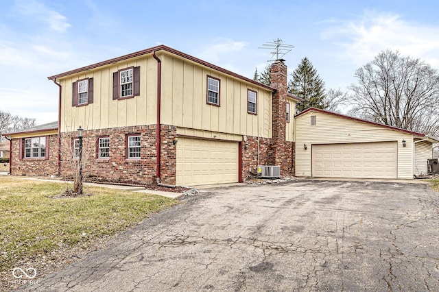 view of front of property featuring central AC, brick siding, and aphalt driveway