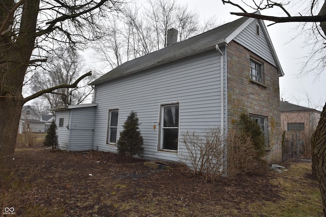 back of house featuring a chimney