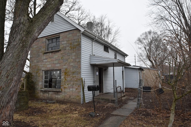 view of front of house featuring stone siding and a chimney