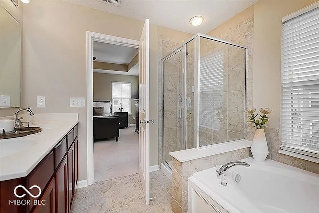 ensuite bathroom featuring a stall shower, ensuite bath, a bath, and vanity