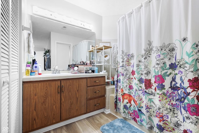 full bathroom featuring wood finished floors, a closet, and vanity