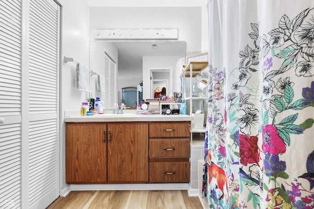 bathroom featuring curtained shower, a closet, vanity, and wood finished floors