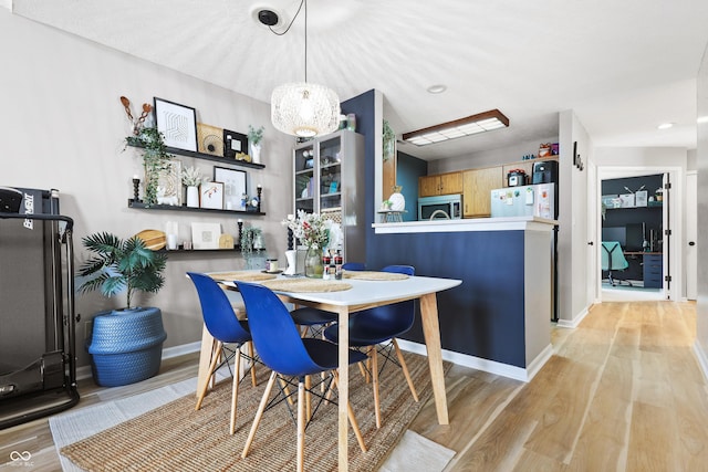 dining area with light wood finished floors and baseboards