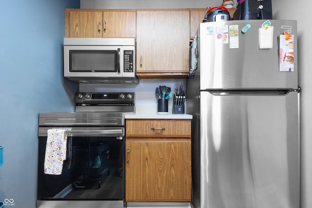 kitchen featuring light countertops, appliances with stainless steel finishes, and brown cabinets