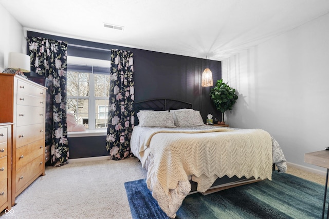 bedroom featuring visible vents and light carpet