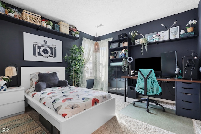 carpeted bedroom with visible vents and a textured ceiling