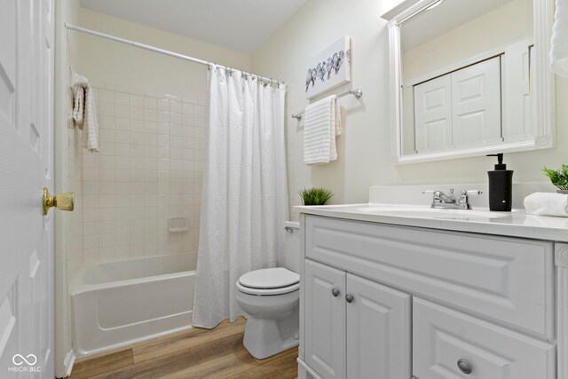 bathroom with wood finished floors, toilet, vanity, and shower / tub combo with curtain