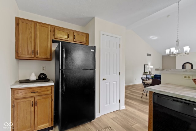 kitchen with black appliances, light wood finished floors, a chandelier, light countertops, and lofted ceiling