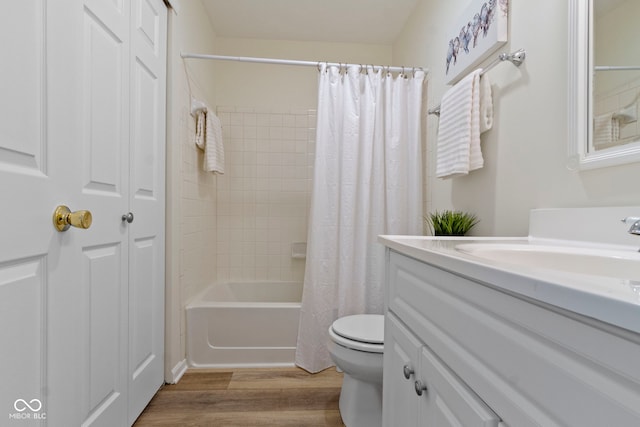 bathroom with wood finished floors, toilet, vanity, and shower / bath combo