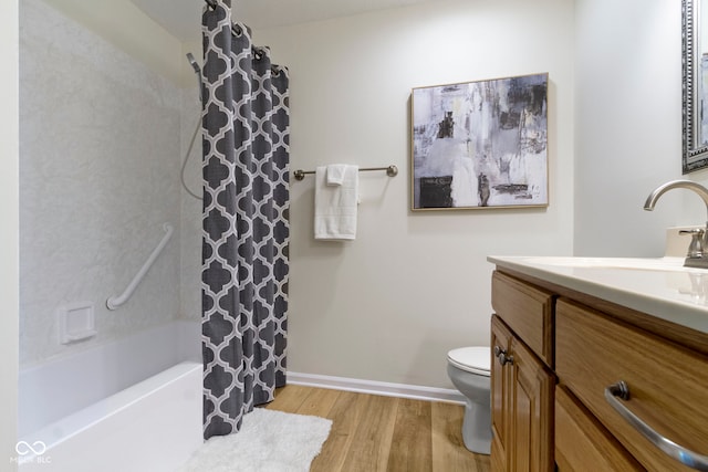 bathroom with wood finished floors, toilet, vanity, shower / bath combination with curtain, and baseboards